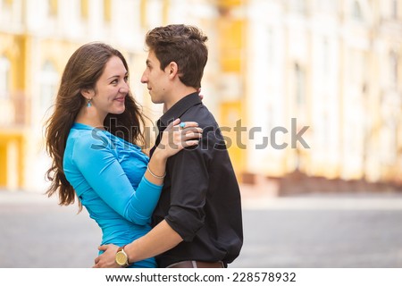 Young couple in love traveling around the beautiful city. Young people hugging and kissing on the streets.Young couple in love, hugging on the street.Happy young couple kissing on the city street.