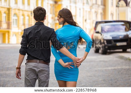 Young couple in love traveling around the beautiful city. Young people hugging and kissing on the streets.Young couple in love, hugging on the street.Happy young couple kissing on the city street.