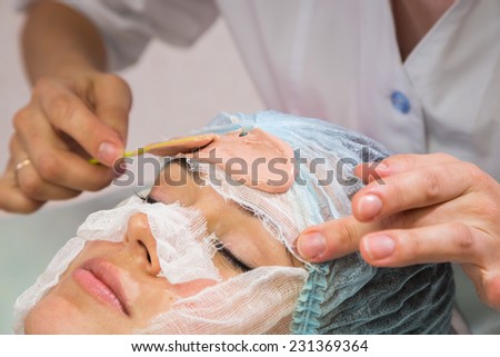 Spa therapy for young woman receiving facial mask at beauty salon.Cosmetic truant, spa, beauty, skin, rubber mask - the concept of skin care. Article about cosmetology.