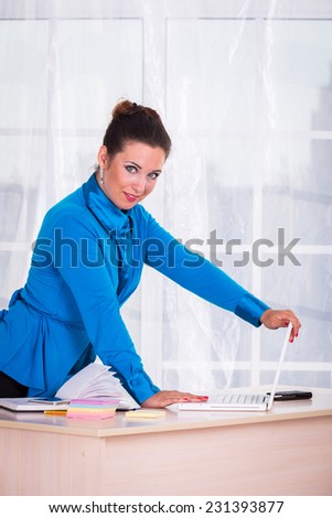 Woman in a business suit. Business woman sitting at the table, working with the computer. Business, work, business woman - business concept girl. The idea about the woman\'s business.