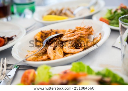 Plate with seafood. Appetizing dish with cooked shrimp. Delicious protein meal. Shrimp, seafood, herbs, Italian cuisine.