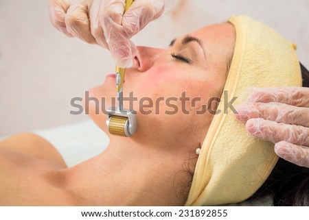 Medical cosmetic procedure. Mikronidling. Beautician performs Dermaroller procedure.young beautiful woman having an injection mesotherapy.osmetic procedures in spa clinic.