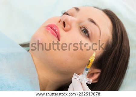 Cosmetic injection in the spa salon. Beautician makes injection into the patient\'s face. Beauty injections, mesotherapy, revitalization, botox - the concept of rejuvenation.