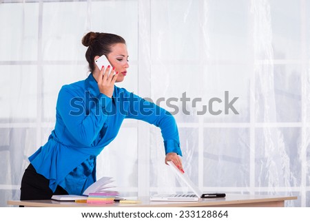 Business woman working in the office at the table.young business woman working at the computer on office background.Portrait of businesswoman with laptop.