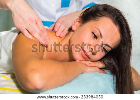 Beautiful young woman relaxing with hand massage at beauty spa. Masseur doing massage on woman body in the spa salon. Beauty treatment concept. Attractive Woman Having Massage With Massage Oil In Spa