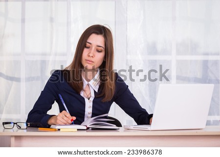 Student works in the office. She works at her laptop.Woman working at the computer on office background.Portrait of businesswoman with laptop.