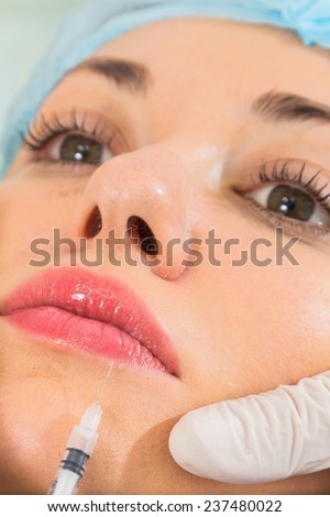 Cosmetic injection in the spa salon. Beautician makes injection into the patient\'s face. the concept of rejuvenation.