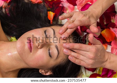Beautiful woman in salon.Spa therapy for young woman receiving facial mask at beauty salon - indoors.Cosmetology, beautician, beautiful background - concept of a facial care.