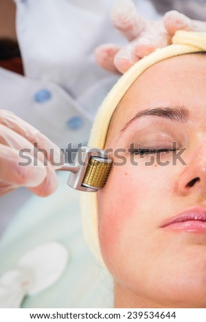 Medical cosmetic procedure. Mikronidling. Beautician performs Dermaroller procedure.young beautiful woman having an injection mesotherapy.Cosmetic procedures in spa clinic.