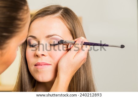 Makeup artist paints the eyebrows model. painting of eyebrows. Makeup artist in a beauty salon doing make-up special brush. Dressing room, fashion, creativity and beauty.