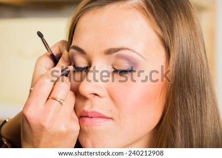 Makeup artist paints the eyebrows model. painting of eyebrows. Makeup artist in a beauty salon doing make-up special brush. Dressing room, fashion, creativity and beauty.