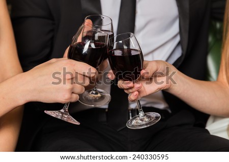 Man and two  woman at meeting are drinking wine. Group of happy young people drink wine. The relationship between a man and a woman - a love triangle, jealousy, betrayal, love, booze.