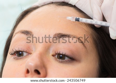 Injection therapy. Anti-aging injections. Beautician doing injection in the face of a beautiful girl.