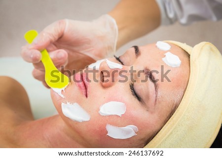 The concept of skin care. Application of special anti-aging masks. A young girl in a beauty salon. Beautician Apply the mask on the face of the model.