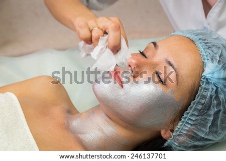 The concept of skin care. Application of special anti-aging masks. A young girl in a beauty salon. Beautician Apply the mask on the face of the model.
