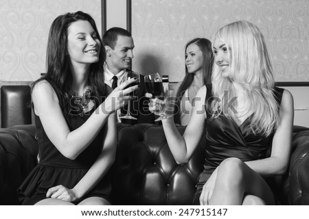A guy and two girls in the room, tense. Group young people drink wine and enjoy the evening. Human feelings - jealousy, love, passion, betrayal.