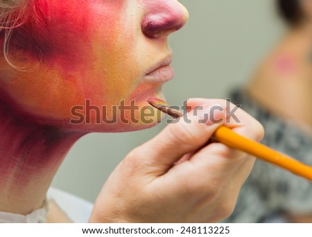 The process of applying color to the face makeup on model. Makeup artist  apply makeup on the model\'s face special makeup brushes. Makeup artist at work.