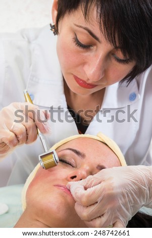 The Beautician and the client in the spa salon. Conducting anti-aging treatments. Revitalization, injection therapy, mikronidling. Medical treatments for the face.
