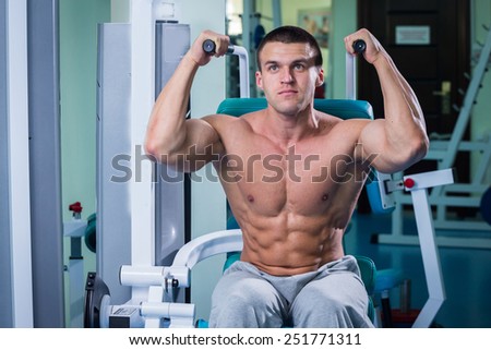 Black and white man in the gym. Working out with weights.Man makes exercises. Sport, power, dumbbells, tension, exercise - the concept of a healthy lifestyle. Article about fitness and sports.