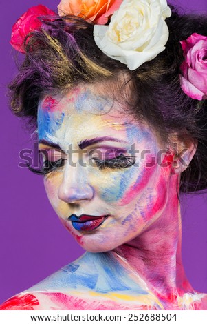 The creative, bright, color makeup. Floral makeup. Art makeup. Beautifully painted lips and eyes. Tone, powder, make-up. Multi-colored roses in her hair girl.