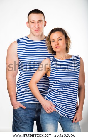 Young couple in love. Athletic man and woman posing on a white background. Muscular strong guy with a beautiful blonde standing arm in arm. Love, husband and wife. Athletic man and woman on white.