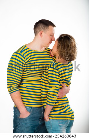 Young couple in love. Athletic man and woman posing on a white background. Muscular strong guy with a beautiful blonde standing arm in arm. Love, husband and wife.