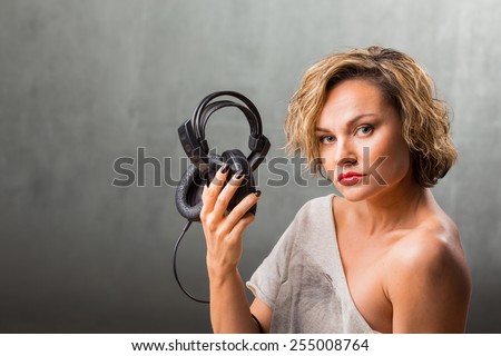 Woman with headphones. Blonde listening to music on stereo headphones. Emotions while listening to music.