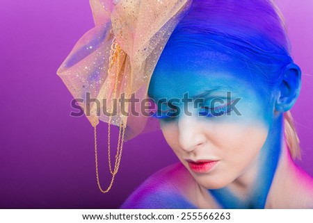 Creative makeup. Airbrush. Blue, indigo, violet makeup. Seasoned professional creative eye make-up, hair. Golden headdress on the girl.