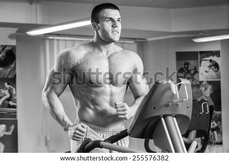 Man in the gym. Working out with weights.Man makes exercises. Sport, power, dumbbells, tension, exercise - the concept of a healthy lifestyle. Article about fitness and sports.