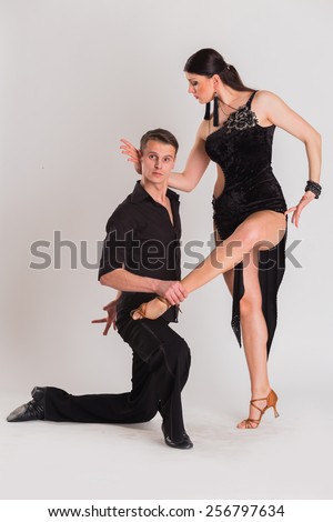 Ballroom dancers dancing. Dancers on a light background. Man and woman dancing. Man and woman posing in dance position.