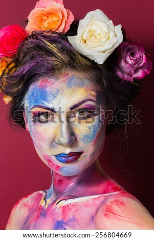 The creative, bright, color makeup. Floral makeup. Art makeup. Tone, powder, make-up. Multi-colored roses in her hair girl. Creative floral make-up on the model.