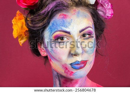 The creative, bright, color makeup. Floral makeup. Art makeup. Tone, powder, make-up. Multi-colored roses in her hair girl. Creative floral make-up on the model.