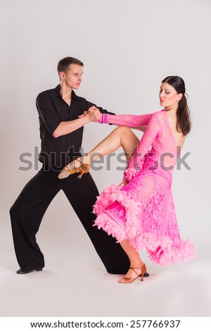 Ballroom dancers dancing. Dancers on a light background. Man and woman dancing. Man and woman posing in dance position.