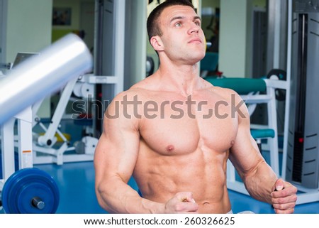 thletic man working out with weights in the gym