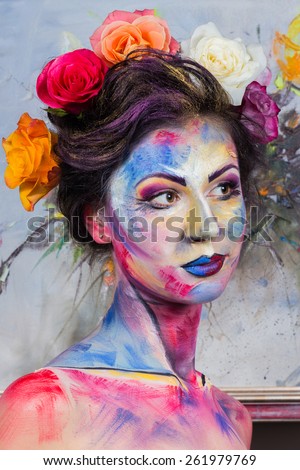 The creative, bright, color makeup. . Beautifully painted lips and eyes. Tone, powder, make-up. Multi-colored roses in her hair girl.