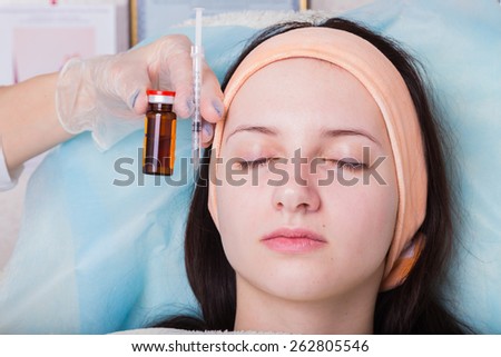 Subcutaneous injection into the girl\'s face. Doctor cosmetologist doing pull-injection in the face model. Syringe, face, needle, lift - the concept of rejuvenation. Tightening of the skin of the face.