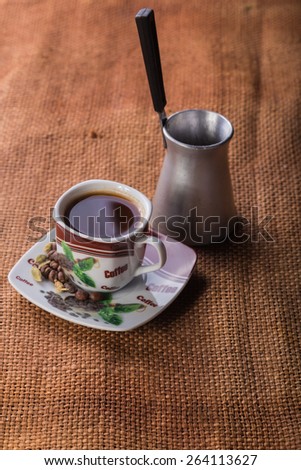 A cup of coffee on the table. Coffee brewed in Arabic. Coffee and Turk for brewing coffee on the table.