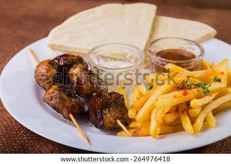 Delicious food. Meat with fries. Eastern food. Skewers of chicken and potatoes. The main dish.