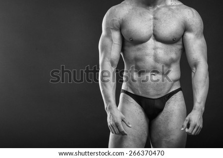 Muscular man bodybuilder. Man posing on a black background, shows his muscles. Bodybuilding, posing, black background, muscles - the concept of bodybuilding. Article about bodybuilding.
