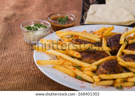 French fries with meat on a plate. Dish with delicious food.