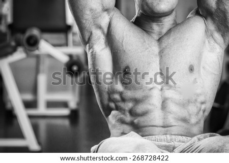 A man pumping abdominal muscles in the gym. Sports. Cubes abdominals. Exercises in the gym.