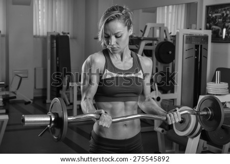 Strong, sexy chick in the gym. Blonde in sexy clothes posing in the gym.