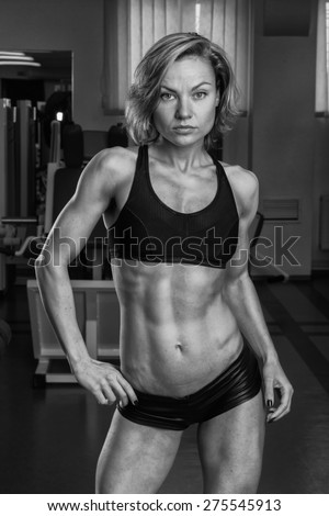 Strong, sexy chick in the gym. Blonde in sexy clothes posing in the gym.