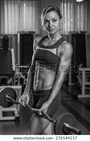 Sexy blonde trains his muscular body in the gym. Sport blonde. Strong girl.