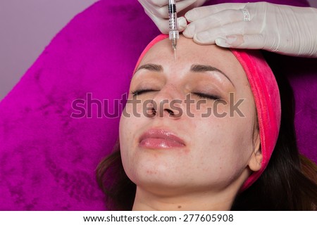 Beauty injections. Beautician makes the injection of anti-aging products in the face of the girl.