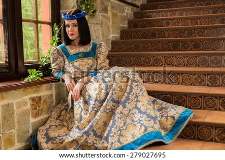 Woman in medieval dress. The girl in a medieval castle. Antique interiors.