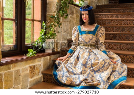 Woman in medieval dress. The girl in a medieval castle. Antique interiors.
