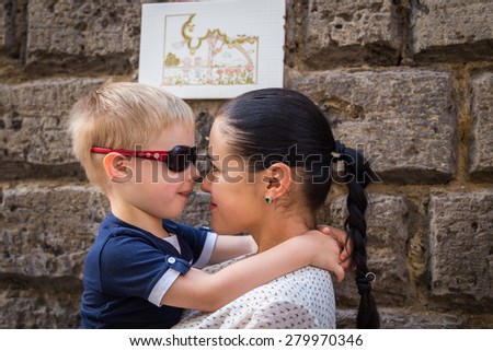 Mom and son. Baby and mom near a stone wall, hugging, kissing, show love. Family values, the concept of family relations.