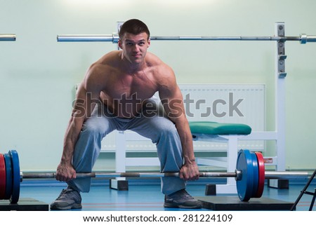 Man is ready to do the exercises. The exercises with a barbell. Sport, health, the concept of a healthy lifestyle.
