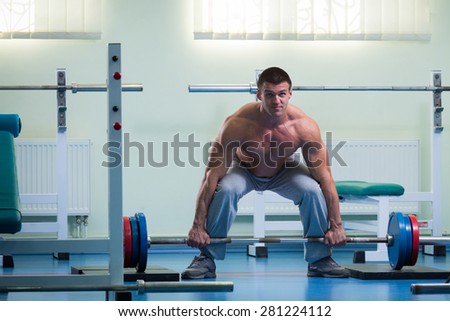 Man is ready to do the exercises. The exercises with a barbell. Sport, health, the concept of a healthy lifestyle.